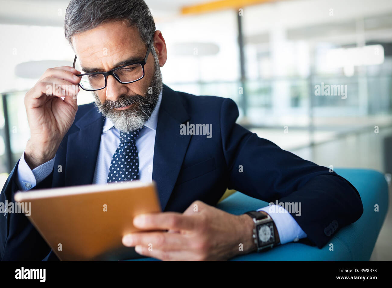Business, tecnologia e persone concetto - senior imprenditore con tablet pc in ufficio Foto Stock
