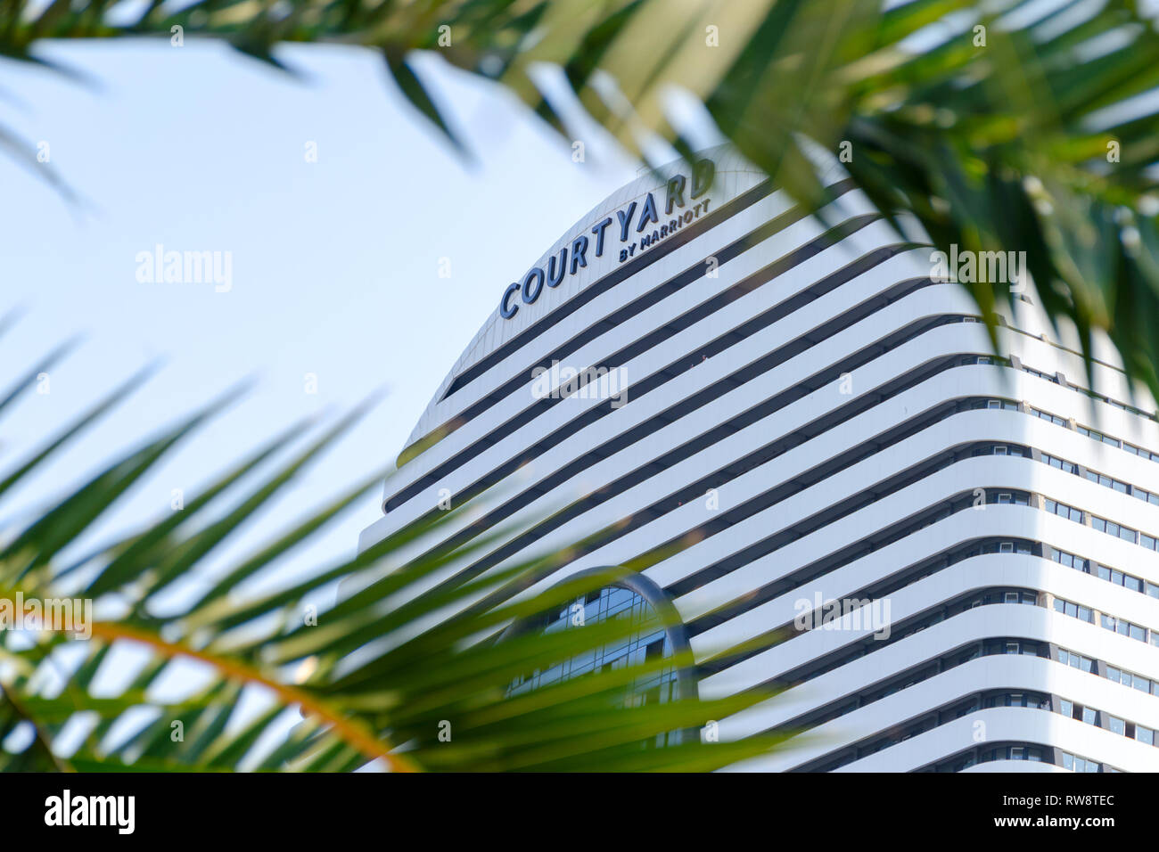 Batumi, Georgia, 2018-10-10: Courtyard by Marriott segno, in frame di foglie di palma. Hotel di lusso di facciata. Marriott International building. Hotel moderno e Foto Stock