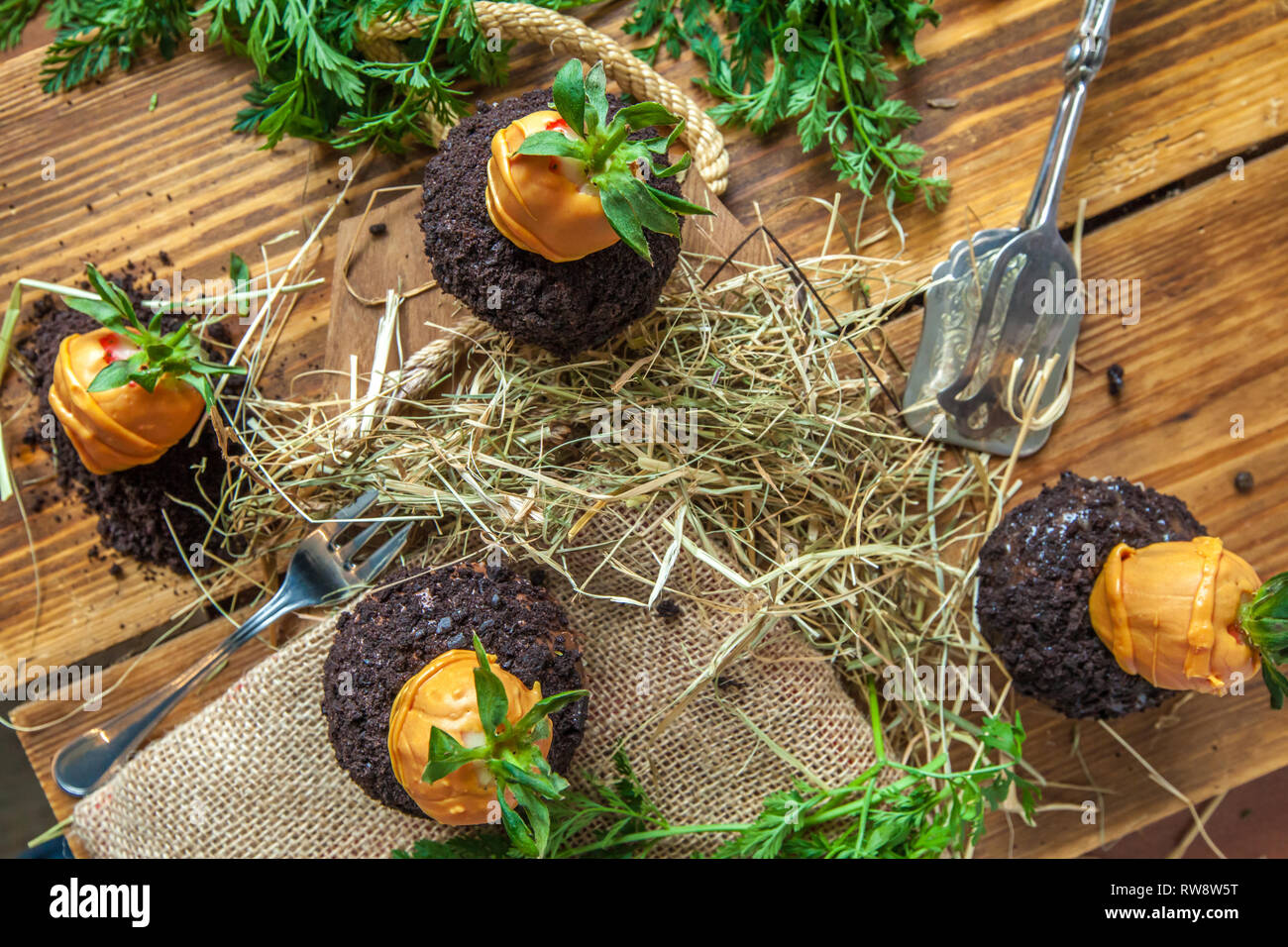 Pasqua tortina su sfondo di legno con cookie terra e fragola carote Foto Stock