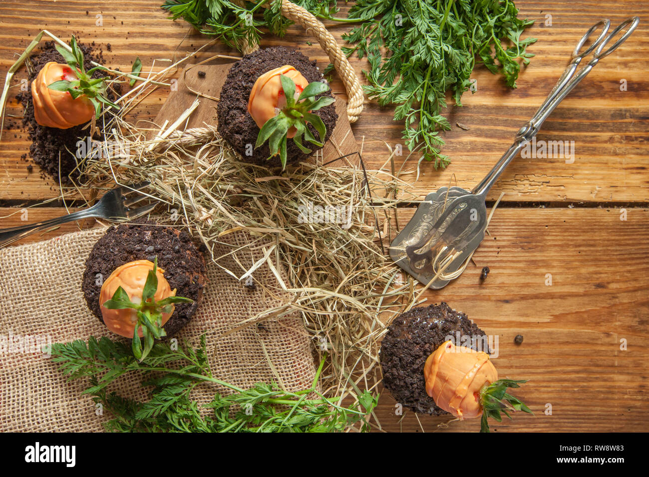 Pasqua tortina su sfondo di legno con cookie terra e fragola carote Foto Stock