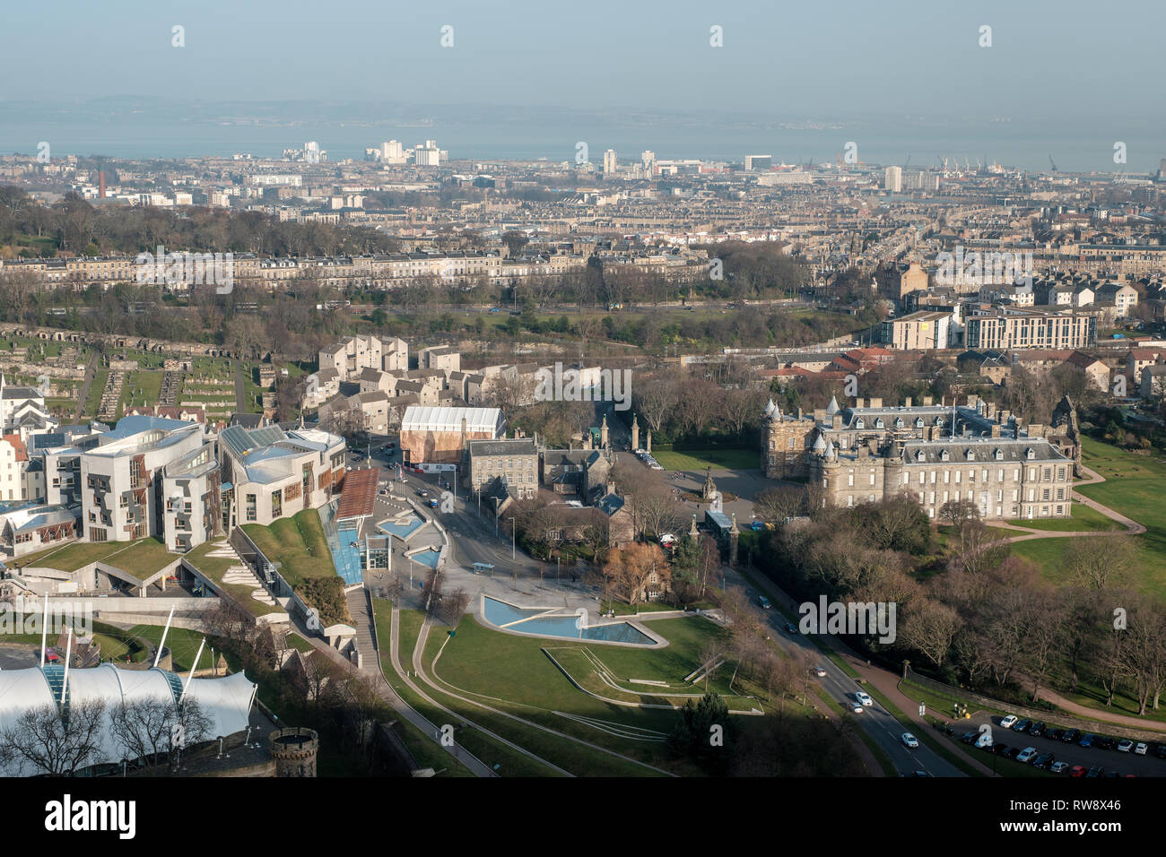 Vista da Salisbury Crags del Palazzo di Holyroodhouse e la Scottish National edificio del Parlamento in una giornata di sole, Edimburgo, Scozia Foto Stock