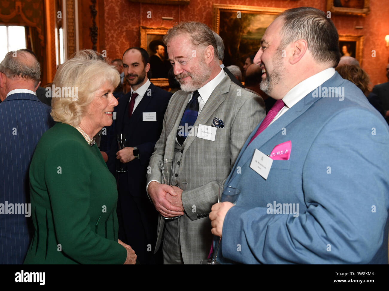 La duchessa di Cornovaglia parla con l'attore Owen Teale e cantante Wynne Evans (a destra) in occasione di un ricevimento a Buckingham Palace a Londra per il cinquantenario dell'investitura del Principe di Galles. Foto Stock