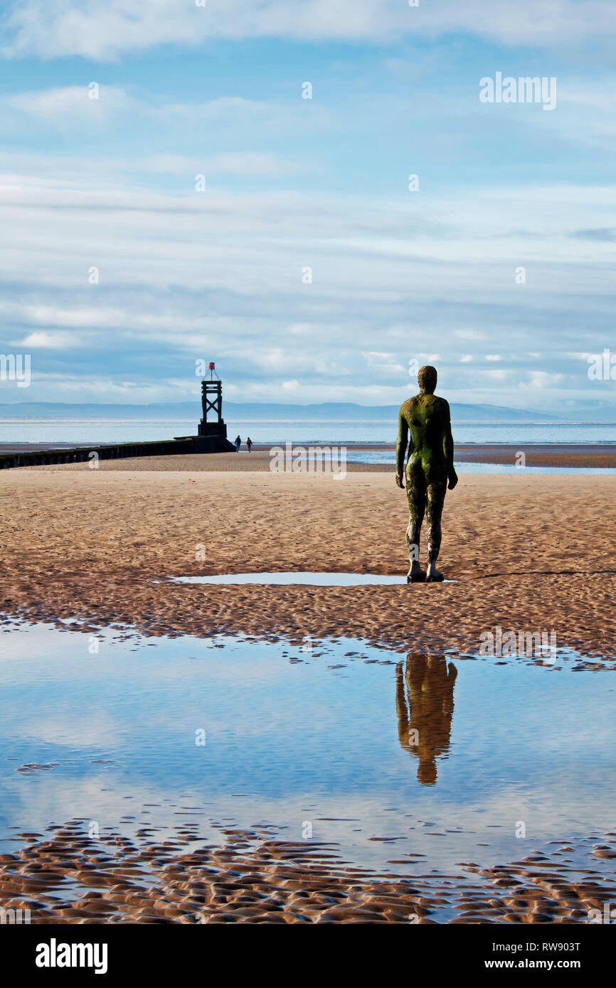 Un uomo di ferro che guarda al mare sulla spiaggia di Crosby, Merseyside Foto Stock