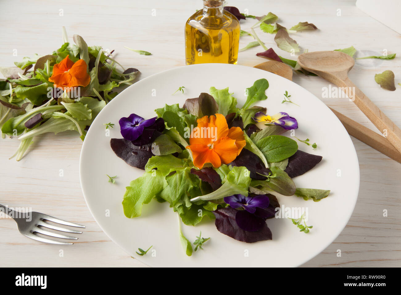 La lattuga e insalata di fiori su woody sfondo bianco Primavera, Pasqua Foto Stock