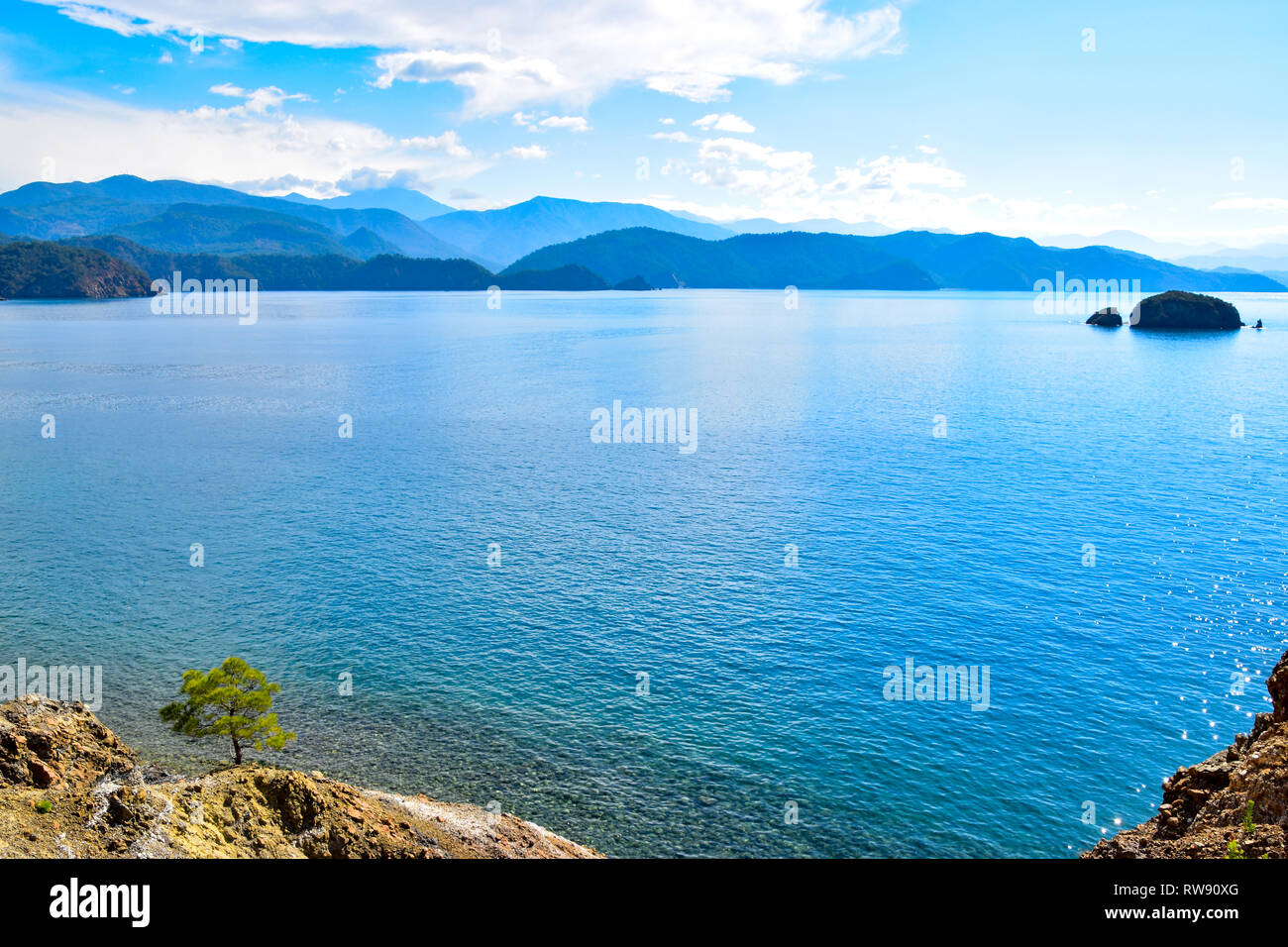 Mediterraneo solitario pino guardando fuori attraverso il mare di Isola e montagne, caicco crociera in barca, il Mare Mediterraneo, Turchia Foto Stock