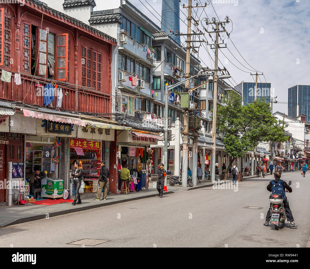 Una street view nella Vecchia Shanghai. Servizio lavanderia appeso fuori ad asciugare sulla finestra binari delle vecchie case, dietro le quali la Shanghai Tower si alza. Cina. Foto Stock