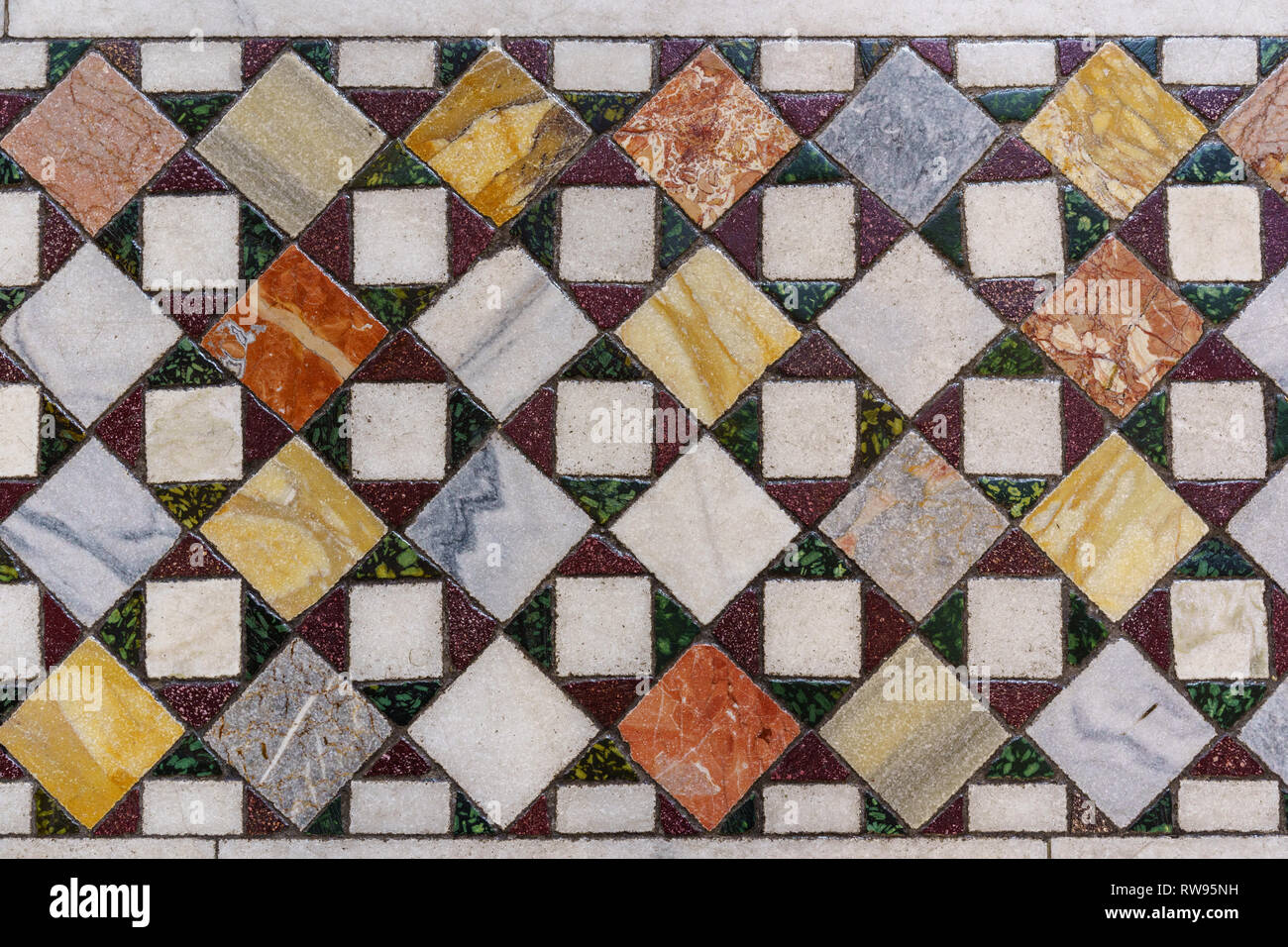 Ornati in mosaico di piastrelle colorate sul pavimento di una chiesa che è in Roma, Italia Foto Stock
