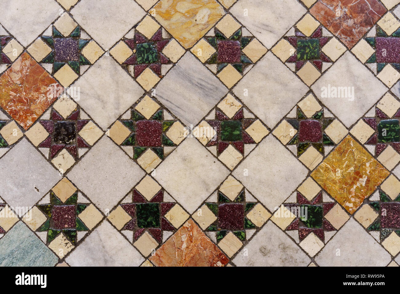 Ornati in mosaico di piastrelle colorate sul pavimento di una chiesa che è in Roma, Italia Foto Stock