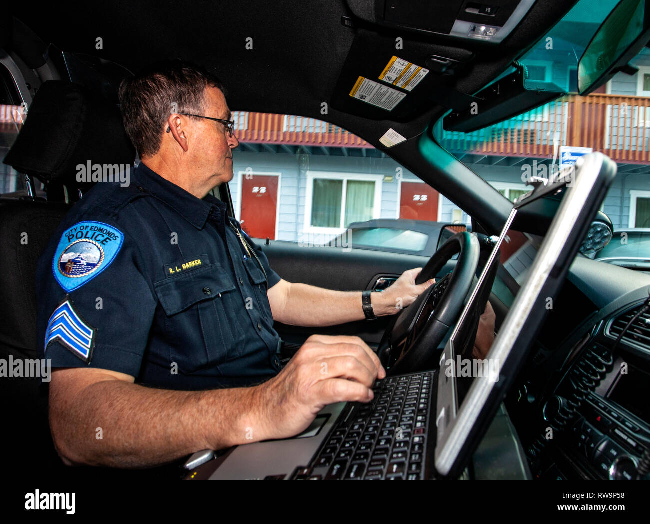 PE00367-00...WASHINGTON - il sergente Robert Barker del Edmonds del Dipartimento di Polizia di controllo per auto rubate in un parcheggio. Foto Stock