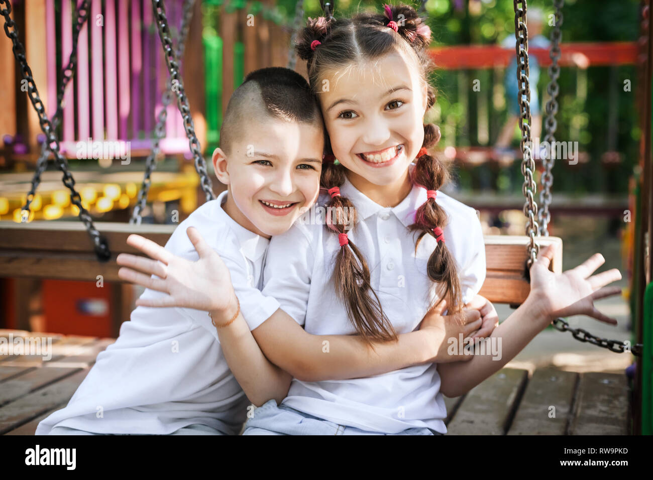 Ragazzo abbracciando la sorella presso il parco giochi Foto Stock