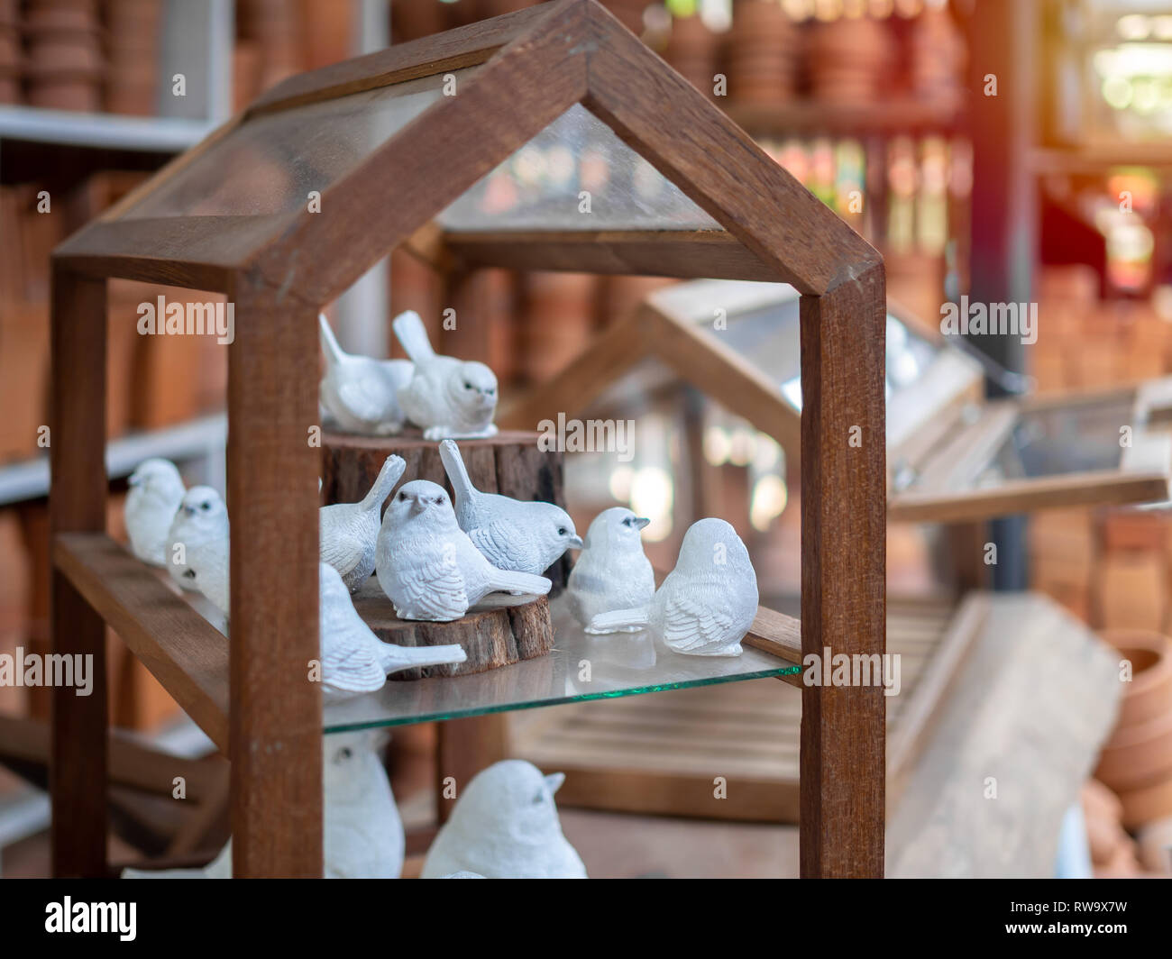 Molti bianco mortaio realistico bird scultura decorazione su casa in legno. Foto Stock