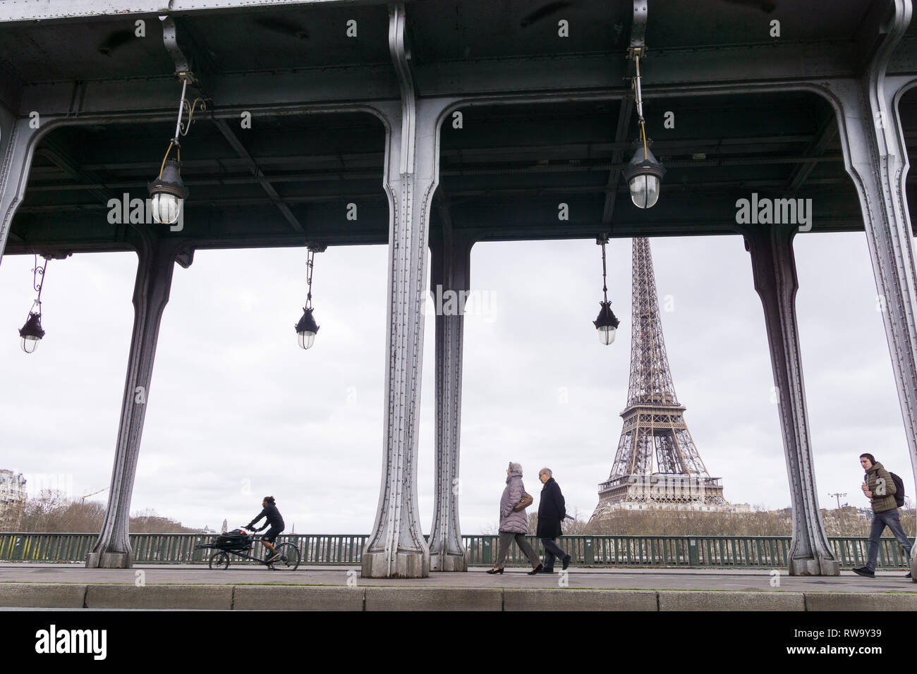 Persone di passaggio lungo il Bir Hakeim bridge con una vista della Torre Eiffel a Parigi, Francia. Foto Stock