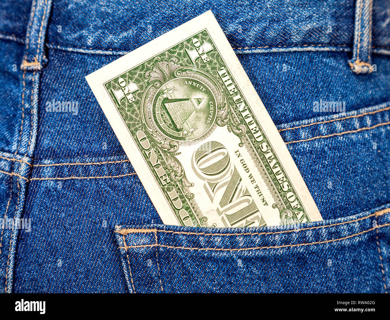Un dollaro statunitense che sporge dalla tasca dei jeans Foto Stock