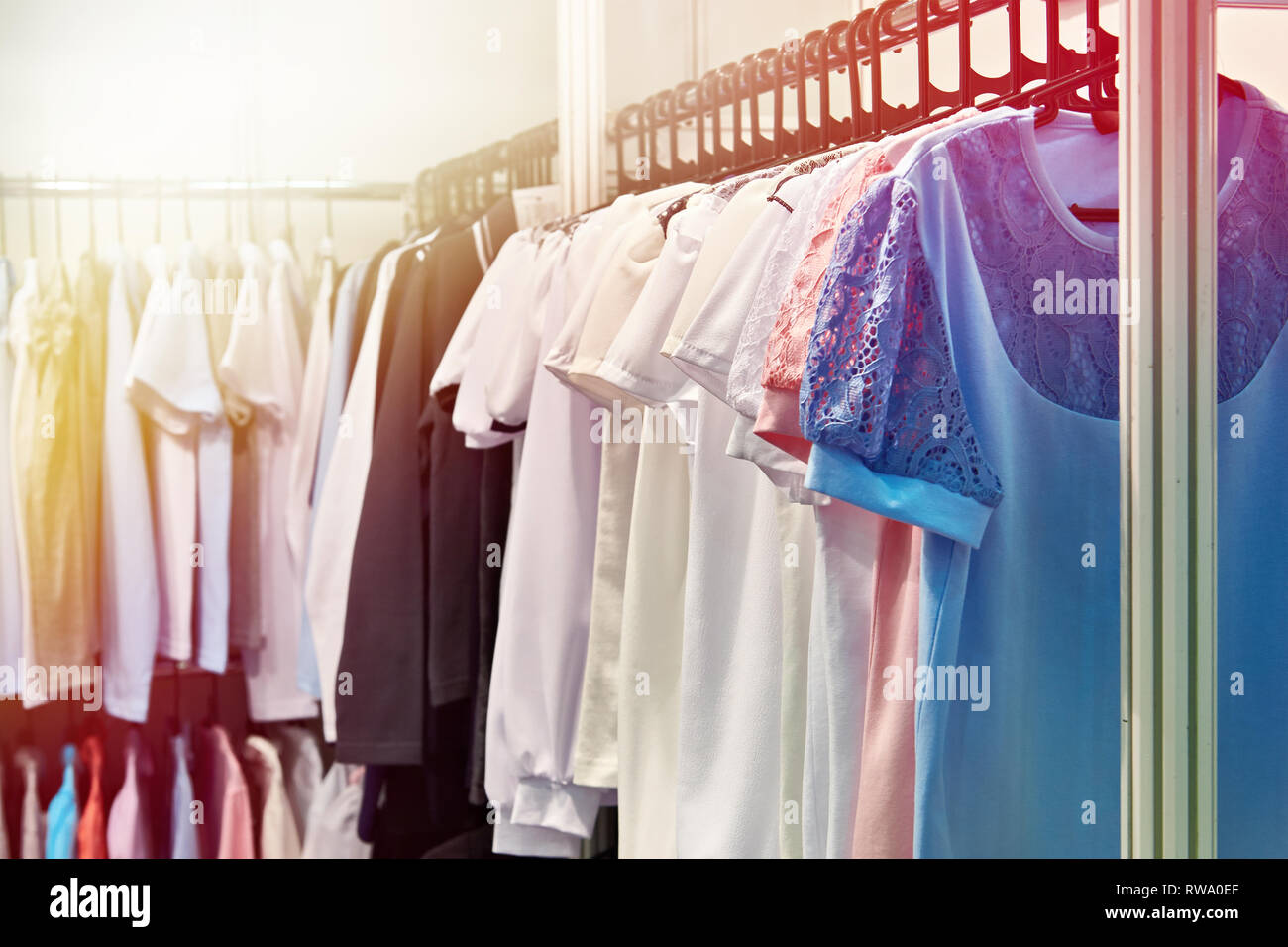 Le donne le camicette e le camicie sulla gruccia in negozio Foto Stock