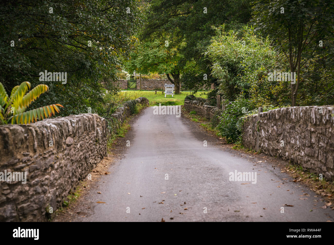 Brendon, Devon, Inghilterra, Regno Unito - Ottobre 03, 2018: attraversando il vecchio ponte in pietra sopra l'est fiume Lyn Foto Stock