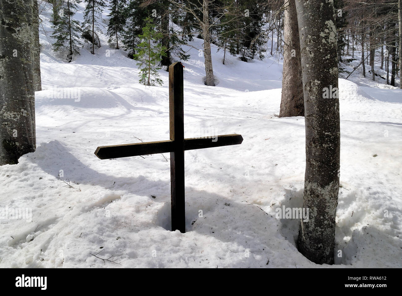 Plockenpass, Austria. La valle della rabbia di flusso in inverno. Durante la prima guerra mondiale in valle ci sono austriaco area dietro la parte anteriore e molti piccoli cimiteri di guerra.i cimiteri sono ancora visibili. Nella foto il piccolo cimitero della Boemia Infanterie Reggimentes n°21 che ha combattuto sul Kleiner Pal mountain.Le tombe sono coperte da neve è possibile vedere solo la grande croce di legno. Foto Stock