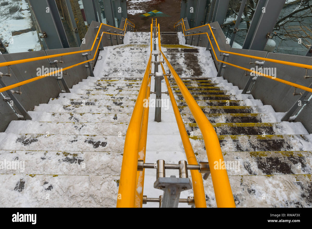 Londra DLR stazione ferroviaria passaggi coperti di neve. Rush Hour pericolo. Pericolose scale scivolose. Il ghiaccio sulla superficie della pavimentazione, rischio di lesioni. Foto Stock