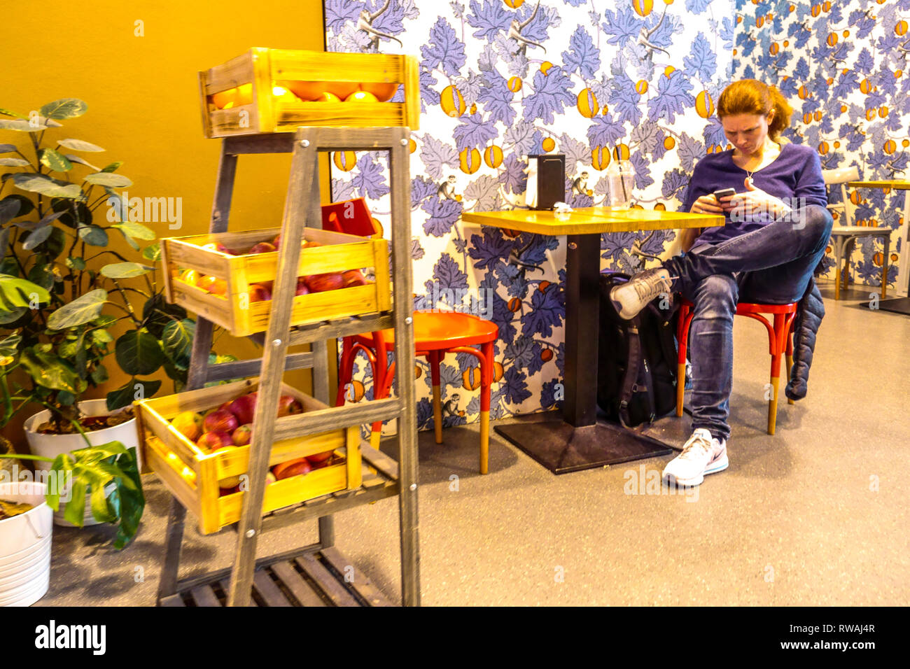 Una giovane donna in un bar che aspetta la sua partenza, all'aeroporto di Vienna, Austria Generation Z Foto Stock