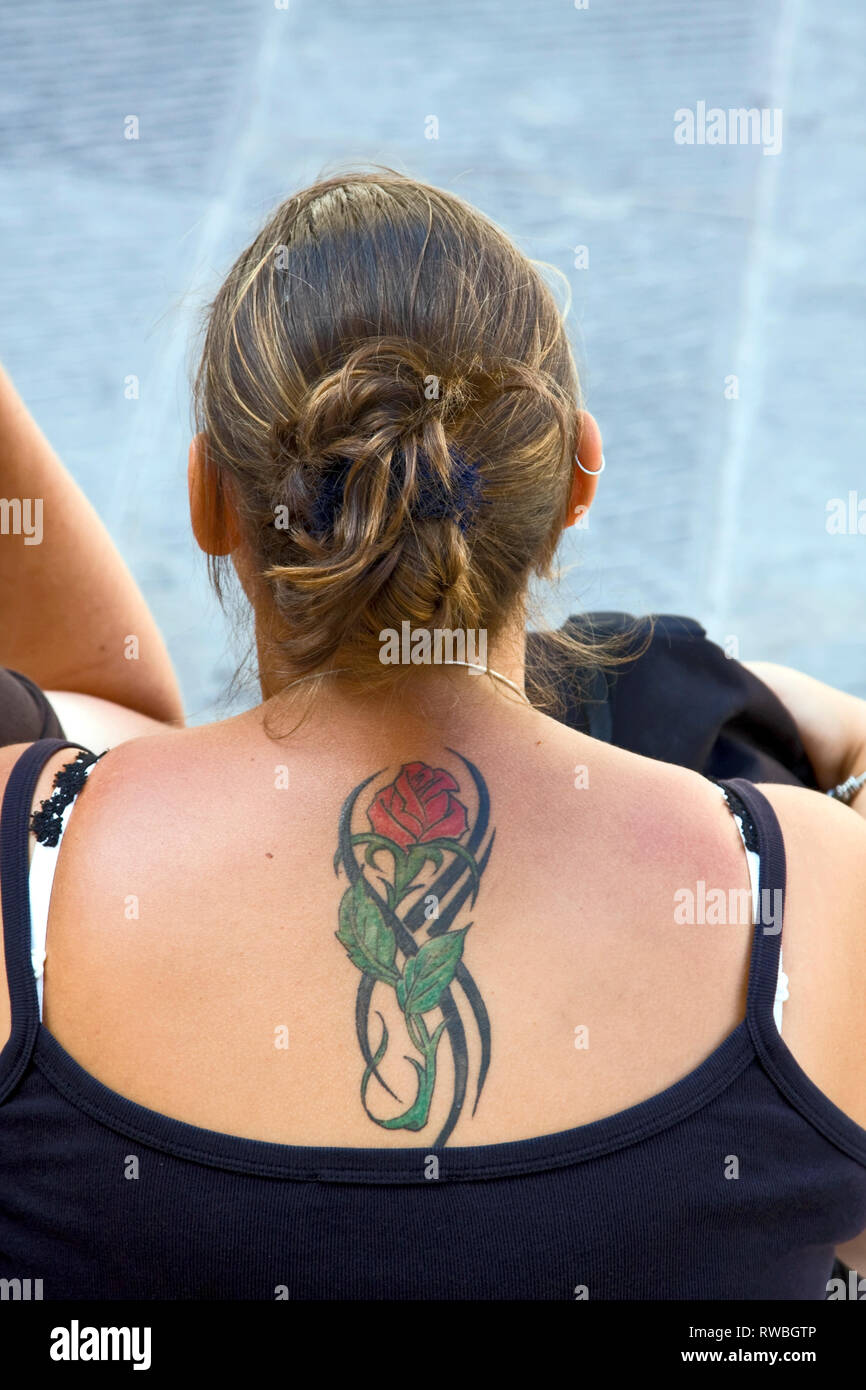 Tatuaggio; red rose; foglie verdi; donna; indietro; piuttosto; decorazione corporea; grazioso, donna, verticale Foto Stock