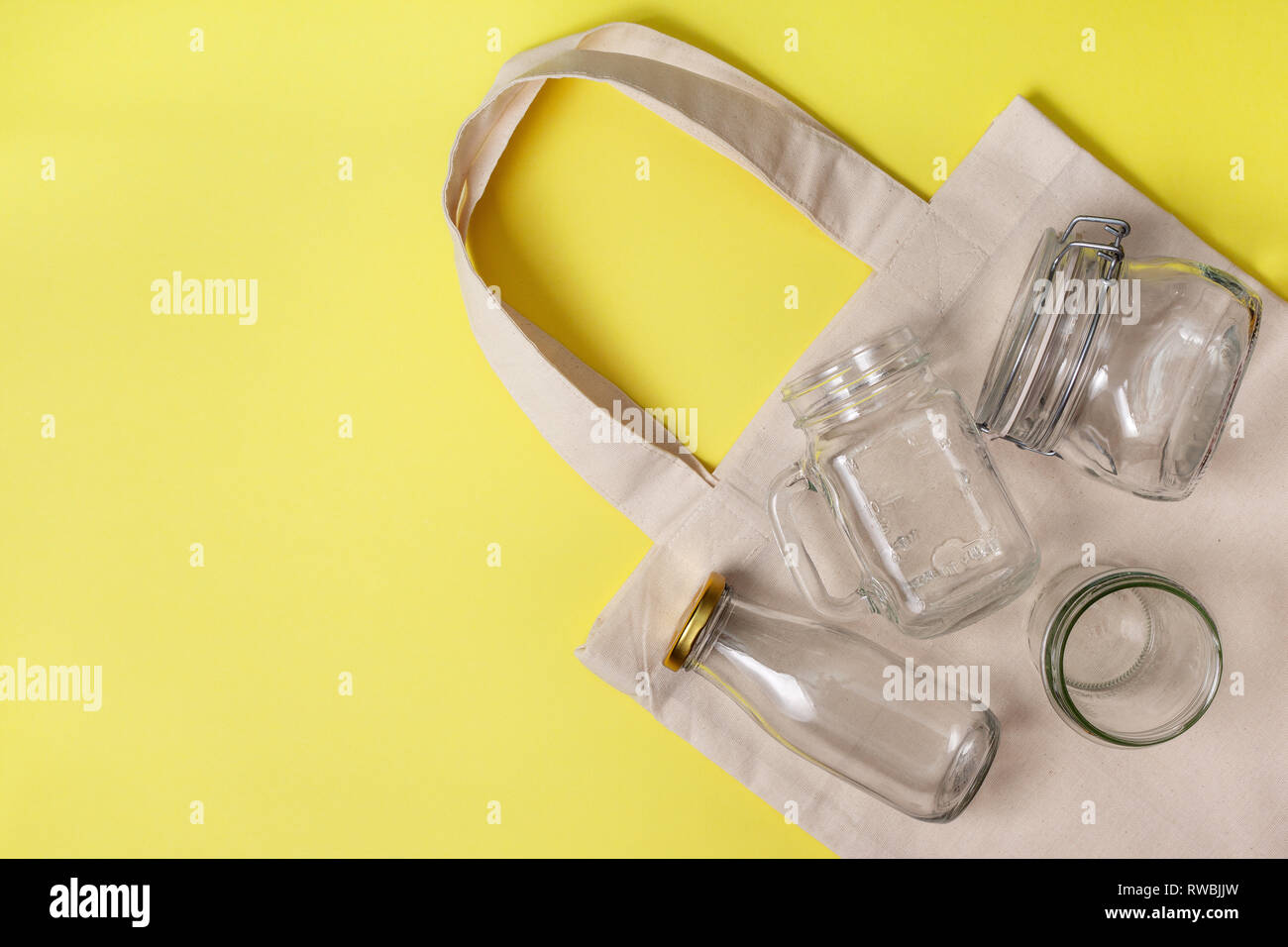 Libera in plastica, eco vivere. eco bag, vasetti di vetro su uno sfondo giallo. vista da sopra Foto Stock