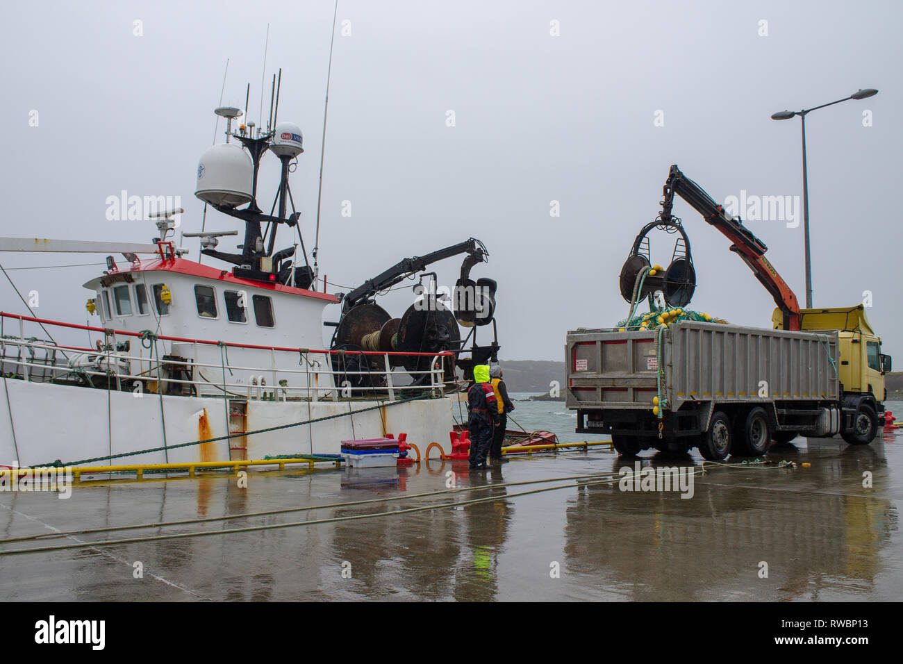 Rete a strascico di essere caricato a bordo di un peschereccio. Foto Stock