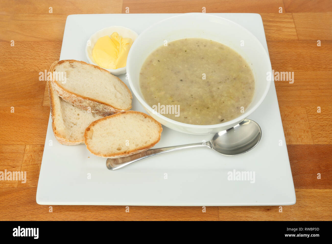 Zuppa di funghi con pane e burro su un tavolo in legno Foto Stock