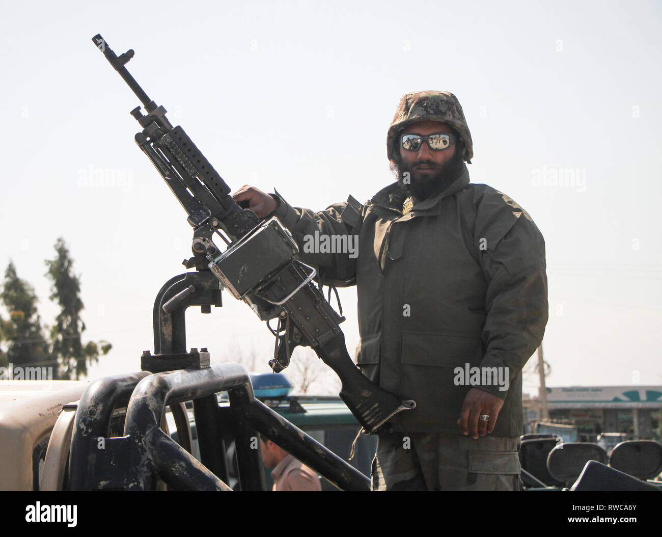 Nangarhar, Afghanistan. 6 Mar, 2019. Un afghano forza di sicurezza stati sorge su un veicolo militare vicino al sito di un attacco nella provincia di Nangarhar, Afghanistan, 6 marzo 2019. Un totale di 21 persone tra cui cinque i pirati informatici sono stati uccisi e altri nove feriti come un blast seguita da colpi di arma da fuoco scosso Jalalabad città, capitale orientale della provincia di Nangarhar Mercoledì, provinciale il portavoce del governo Attaullah Khogiani detto. Credito: Saifurahman Safi/Xinhua/Alamy Live News Foto Stock