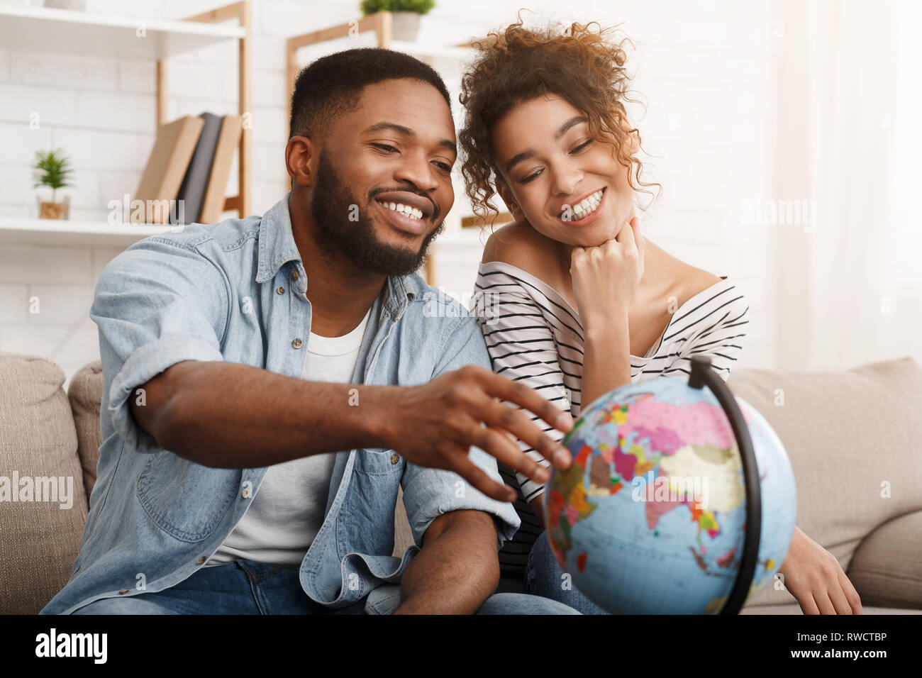 African-american giovane con globo scelta di posto per i viaggi Foto Stock