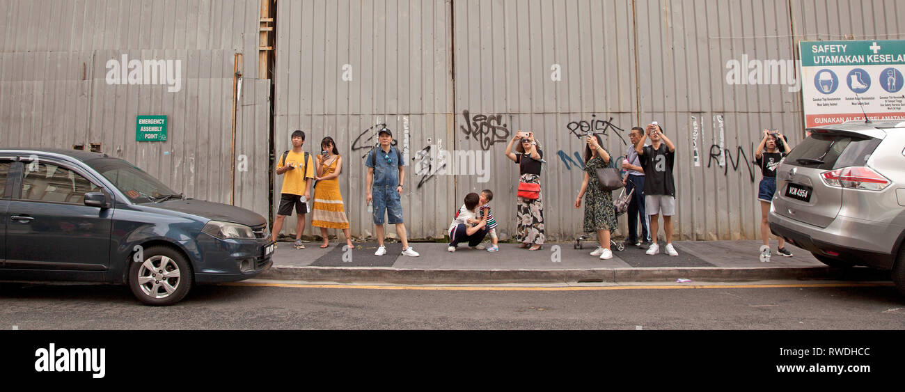 I turisti scattare fotografie con il loro smartphone, Kuala Lumpur, Malesia Foto Stock