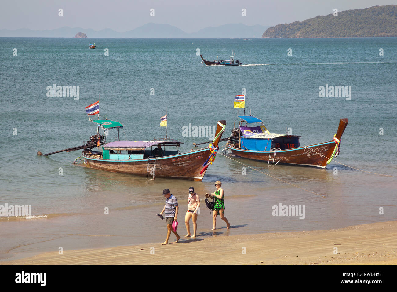 Lunga coda di barche per island hopping, Aonang, Krabi, Thailandia, i turisti sulla spiaggia Foto Stock