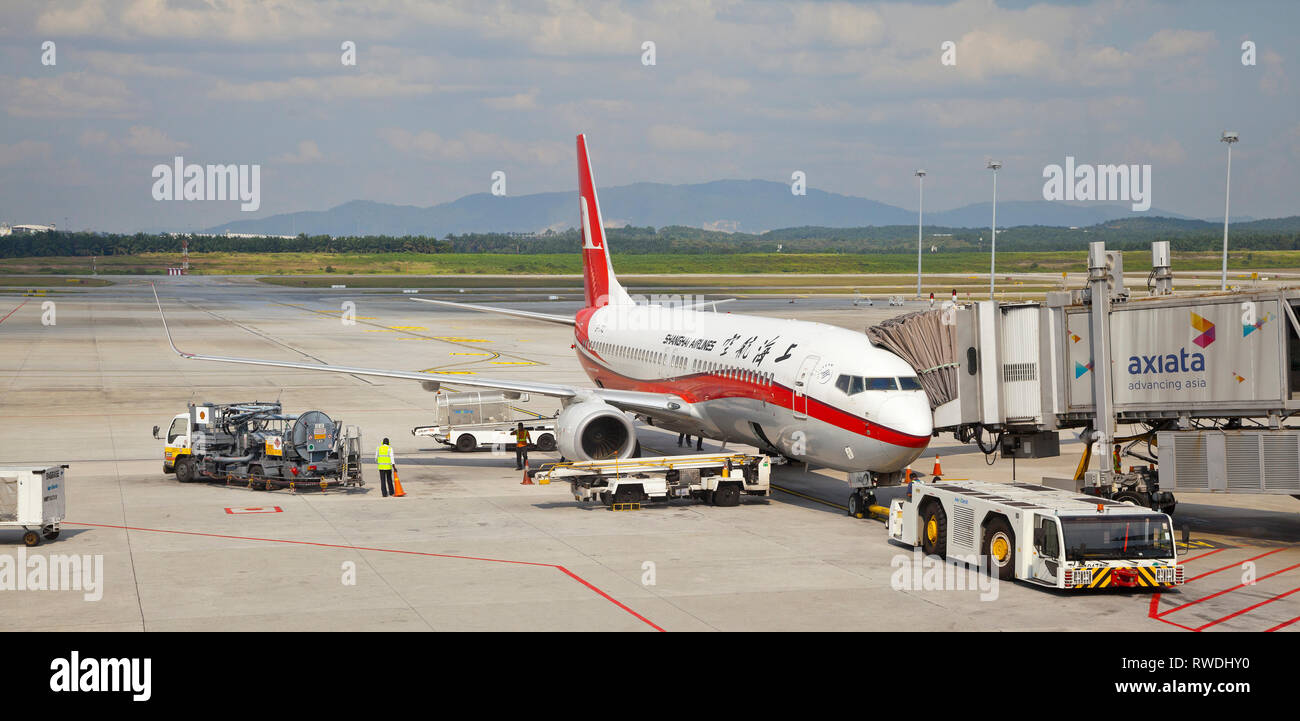Aeroporto scena con aerei e veicoli di supporto, bagagli caricatore, refueller, tunnel passeggeri, bright sun. Foto Stock