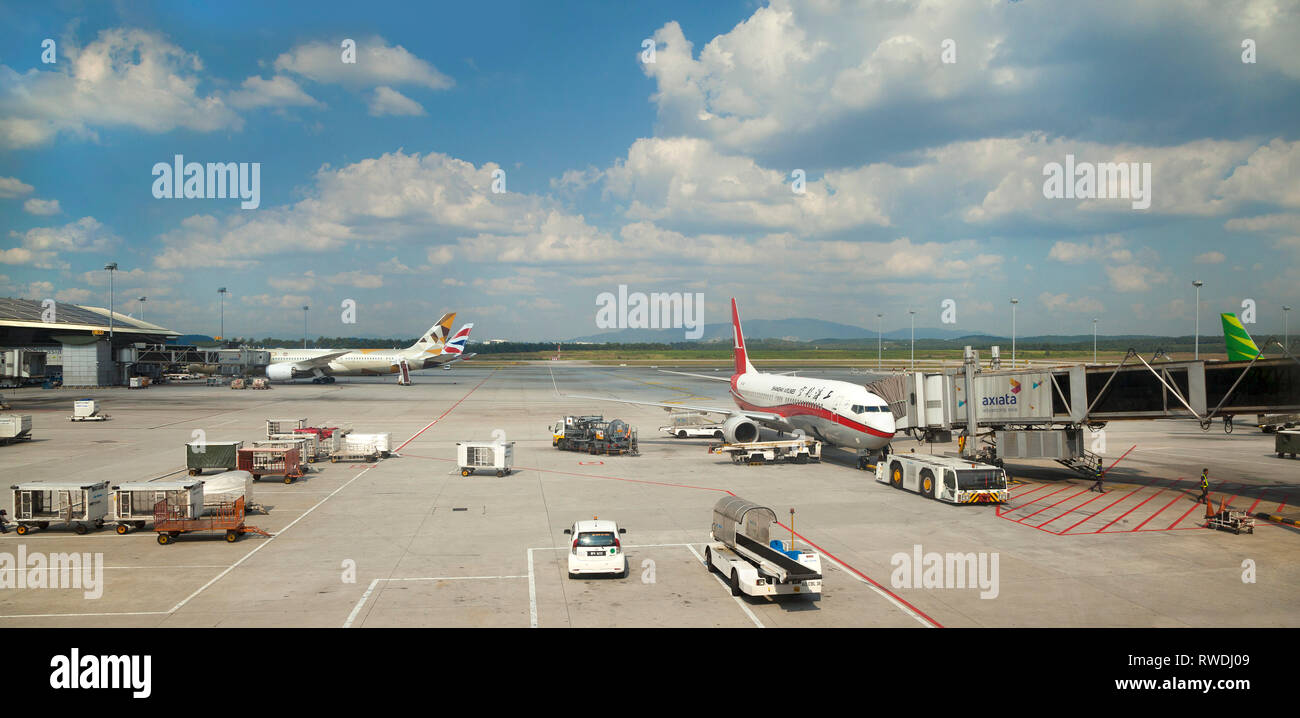 Aeroporto scena con aerei e veicoli di supporto, bagagli caricatore, refueller, tunnel passeggeri, bright sun. Foto Stock