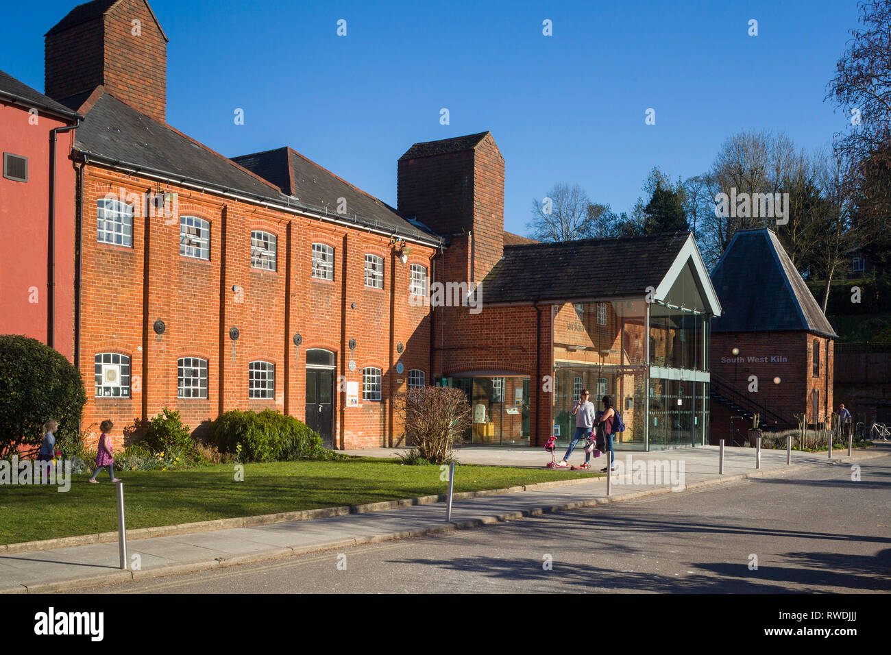 Due giovani madri chat davanti a lui Farnham Maltings, il museo, arti, teatro e un centro comunitario in una birreria convertito in Farnham, Surrey. Foto Stock