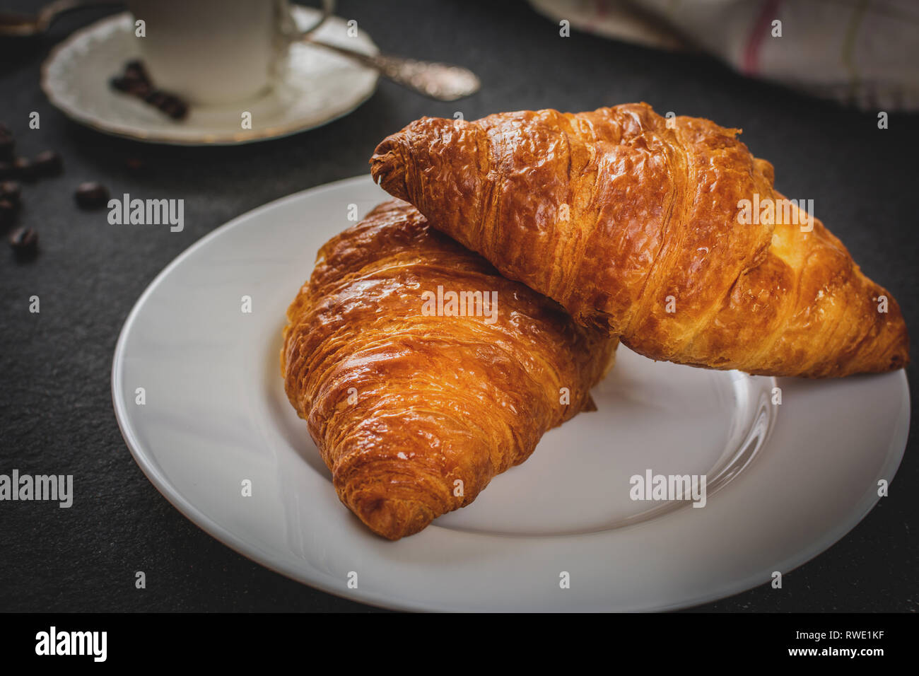 Tradizionale prima colazione francese croissant e caffè nero sul tavolo di pietra Foto Stock