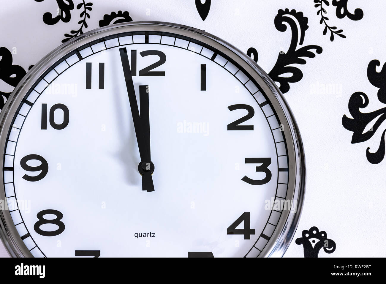 Grande Orologio argento sulla parete che mostra quasi a mezzanotte Foto Stock