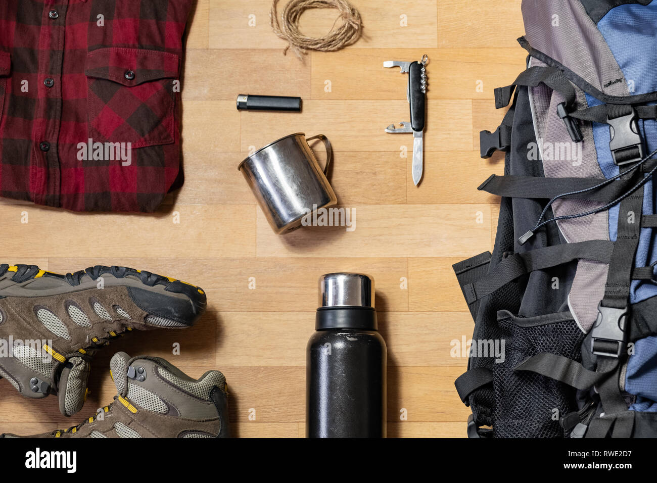 Preparazione per un viaggio escursionistico: backpacking cose e vestiti  laici piana. Vista dall'alto di scarponi da montagna, zaino turistico e  campeggio accessori sul pavimento Foto stock - Alamy