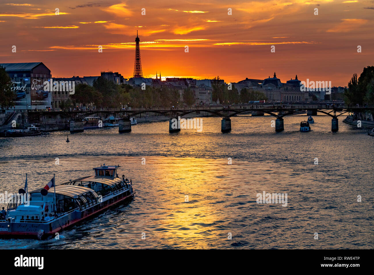 Parigi e la Senna che scorre sotto il Pont des Art al tramonto, con la Torre Eiffel in lontananza, Parigi, Francia Foto Stock