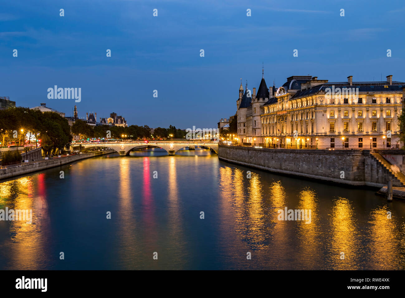 Luci che riflettono fuori del Fiume Senna di notte da Pont Neuf, con Pont au change e le torrette della Conciergerie sull'Île de la Cité , Parigi Foto Stock