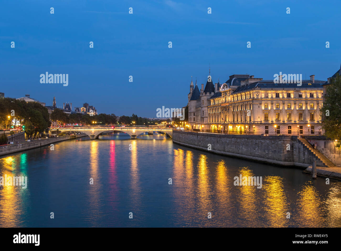 Luci che riflettono fuori del Fiume Senna di notte da Pont Neuf, con Pont au change e le torrette della Conciergerie sull'Île de la Cité , Parigi Foto Stock