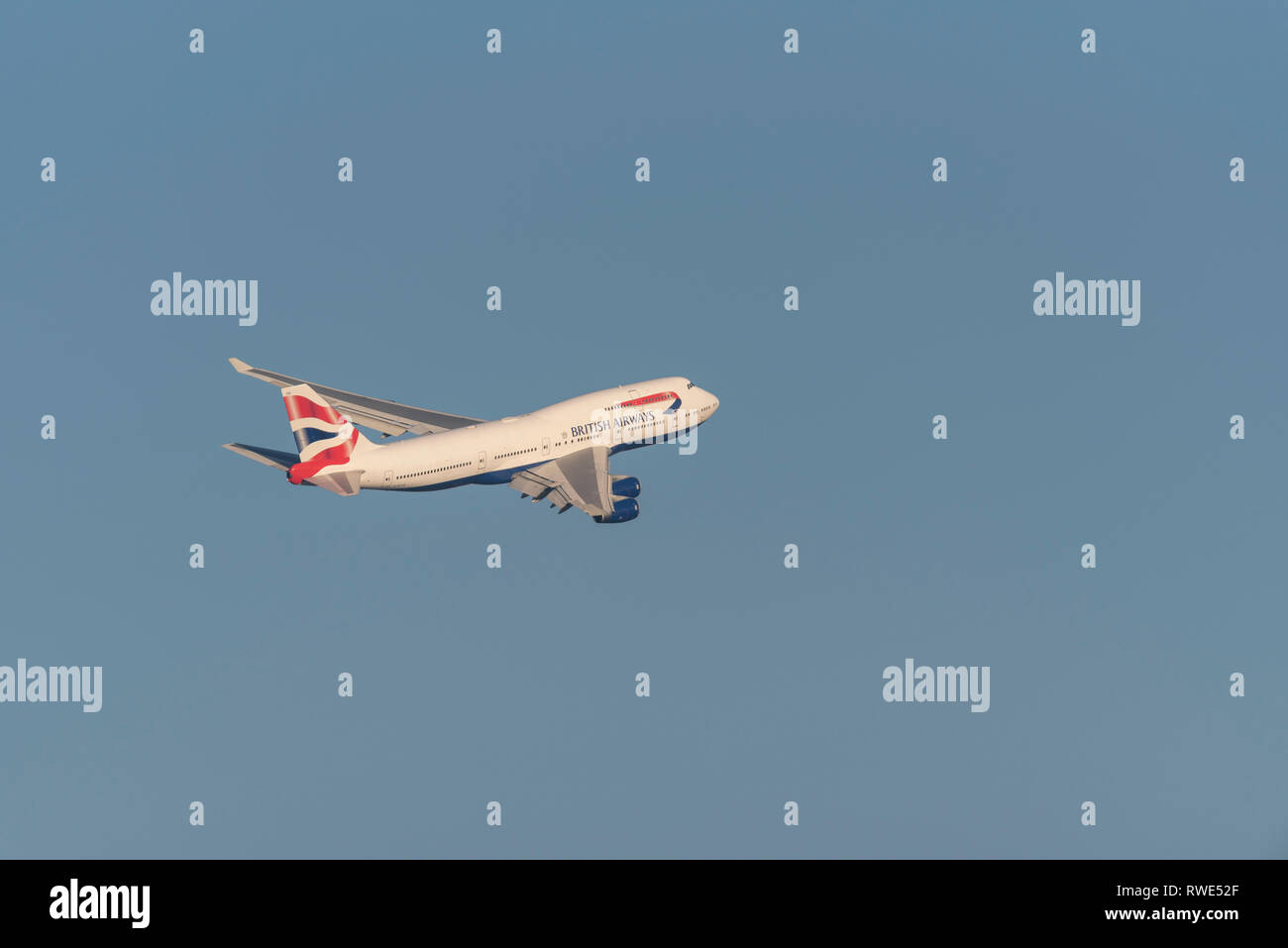 British Airways Boeing 747 Jumbo Jet aereo di linea G-BYGE decolla dall'aeroporto di Londra Heathrow, Regno Unito, in cielo blu Foto Stock