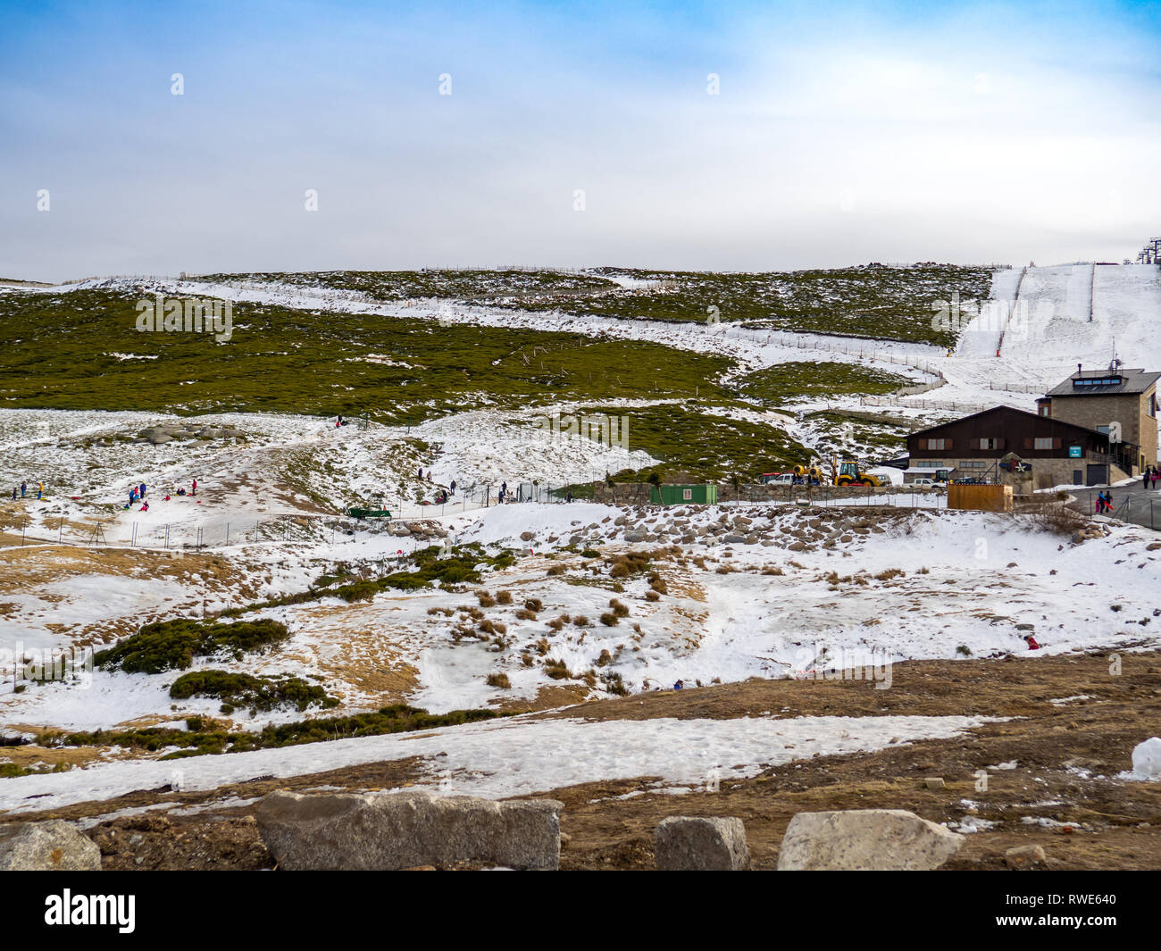 Irriconoscibile persone scivolando sul ghiaccio in un pendio in montagna su La Covatilla, Bejar (Salamanca) Foto Stock