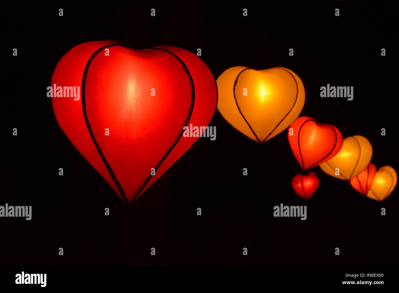 Forma di cuore lampion lanterna al parco di notte tempo isolato in nero Foto Stock