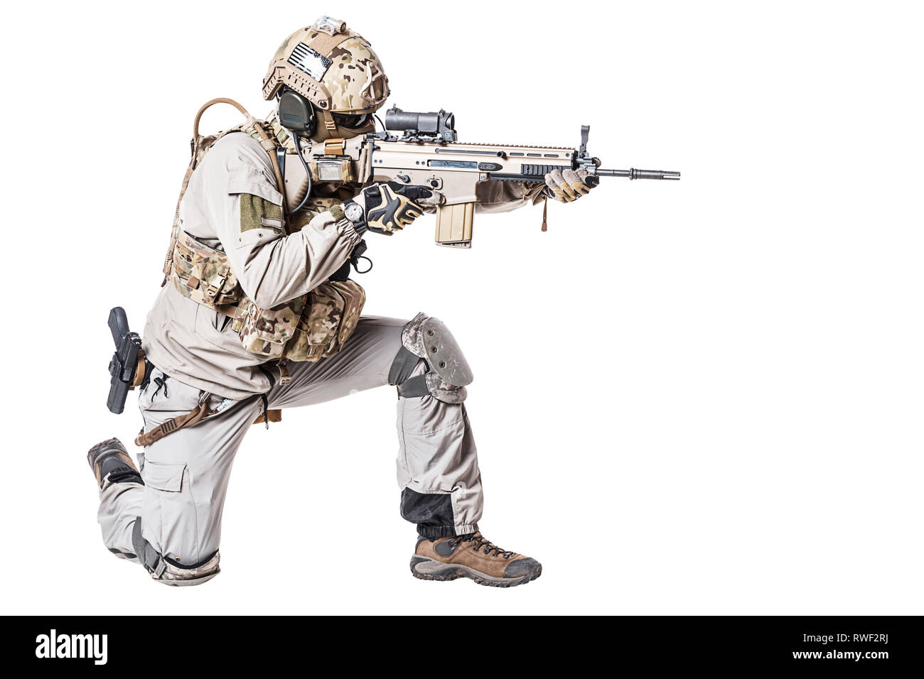 Soldato dell'esercito in Protective Combat Uniform riprese il fucile di assalto in posizione in ginocchio. Foto Stock