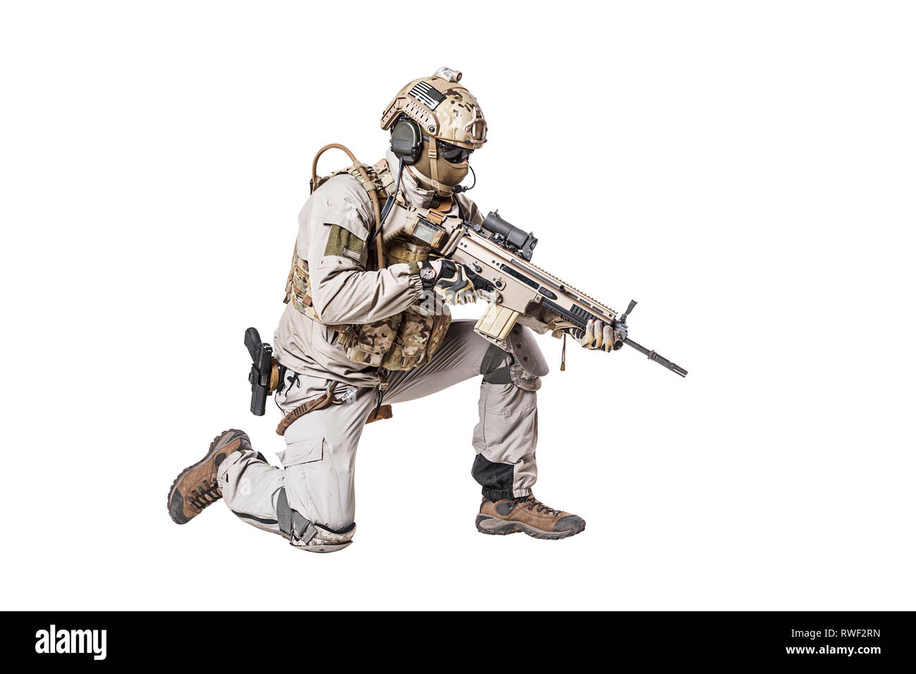 Soldato dell'esercito in Protective Combat Uniform riprese il fucile di assalto in posizione in ginocchio. Foto Stock