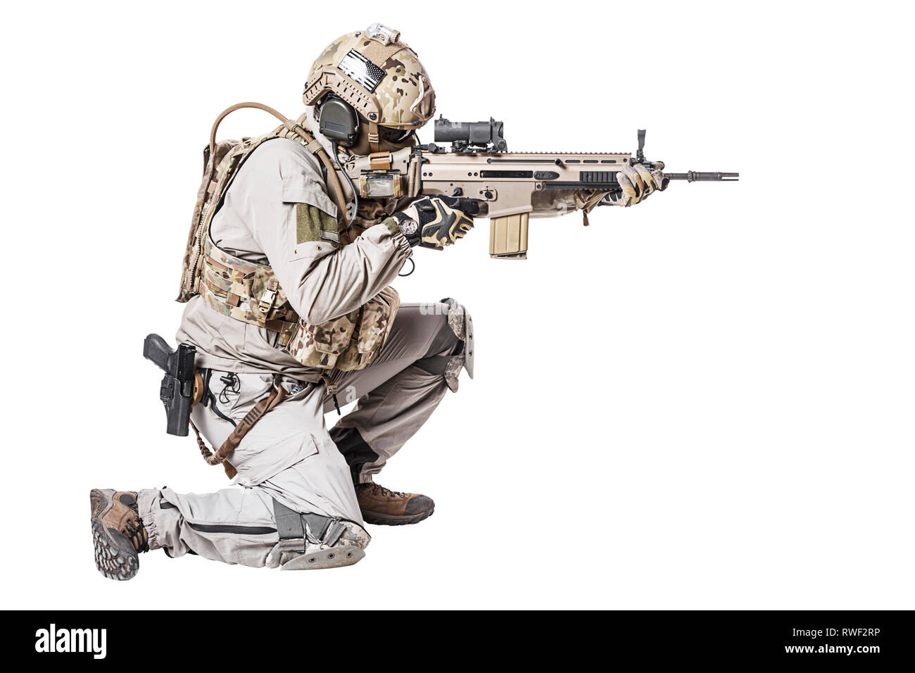 Soldato dell'esercito in Protective Combat Uniform riprese il fucile di assalto in posizione in ginocchio. Foto Stock