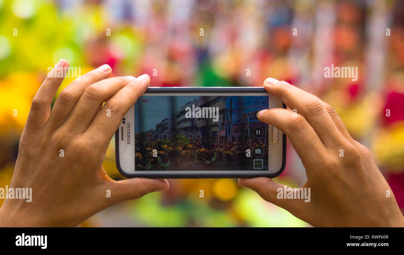 Prendendo la foto dello smartphone con le mani a Dinagyang Festival, Iloilo - Filippine Foto Stock
