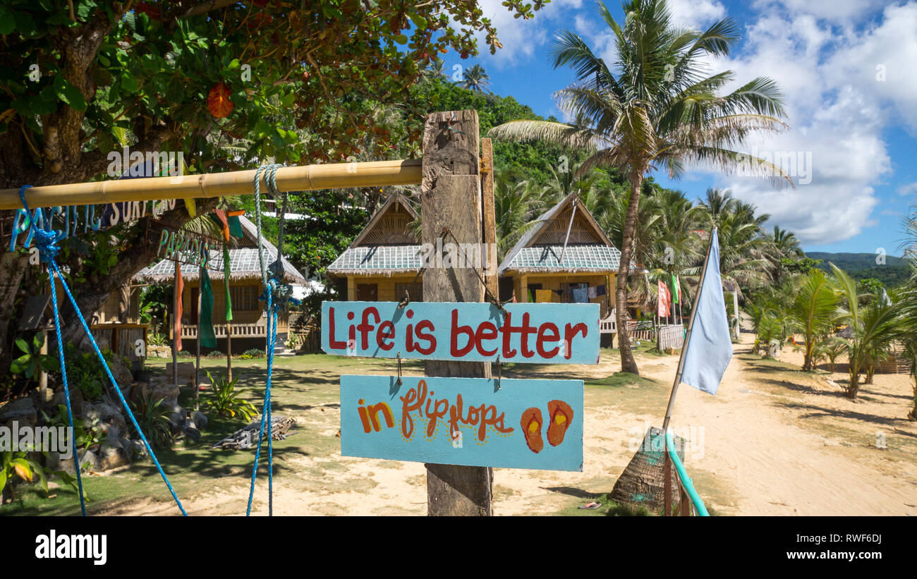 "La vita è migliore in flip flop" segno a beach resort in Catanduanes, Filippine Foto Stock