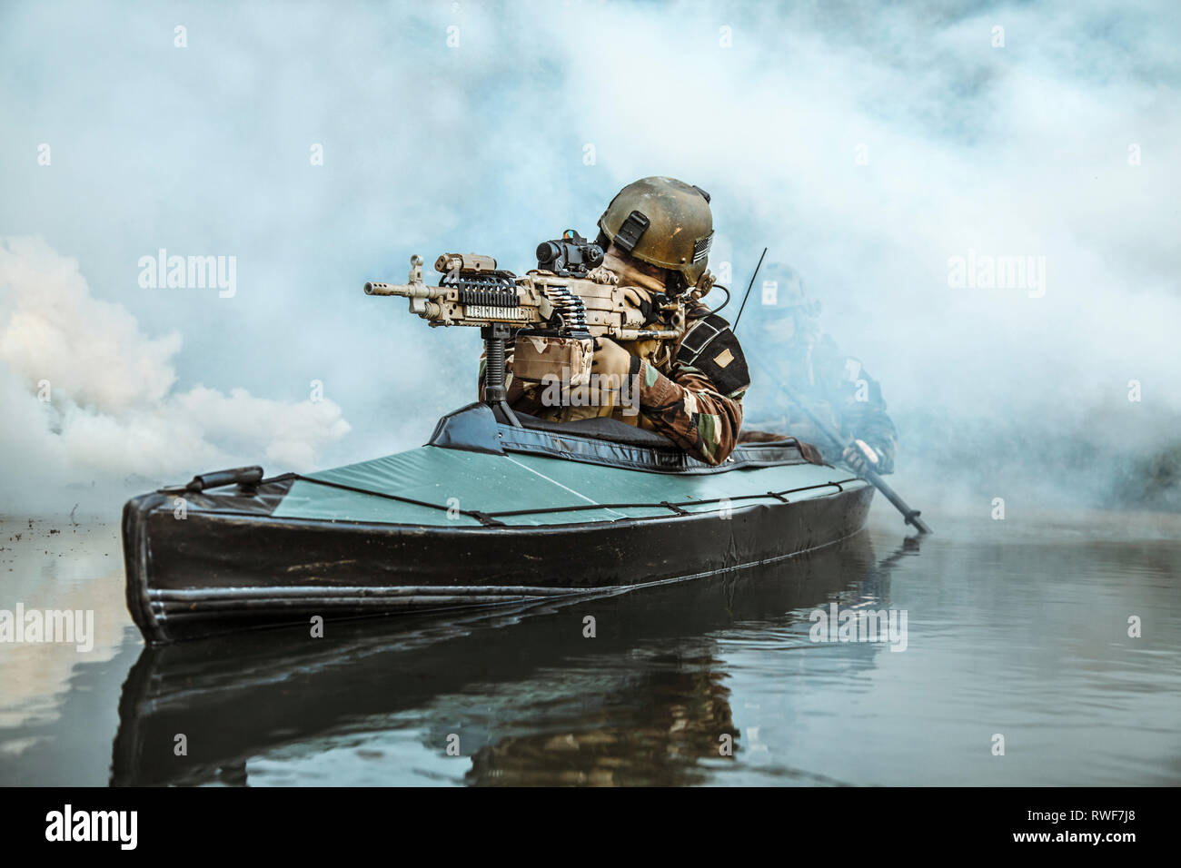 Le forze speciali operatore armato di mitragliatrice, Esercito di canoa kayak attraverso la nebbia di fiume. Foto Stock