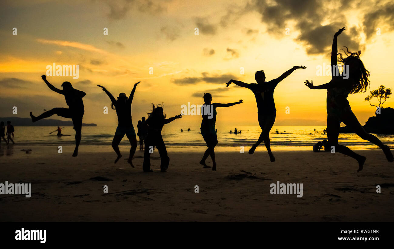 I turisti amici jump shot sulla bianca spiaggia al tramonto - Isola Boracay, Panay - Filippine Foto Stock