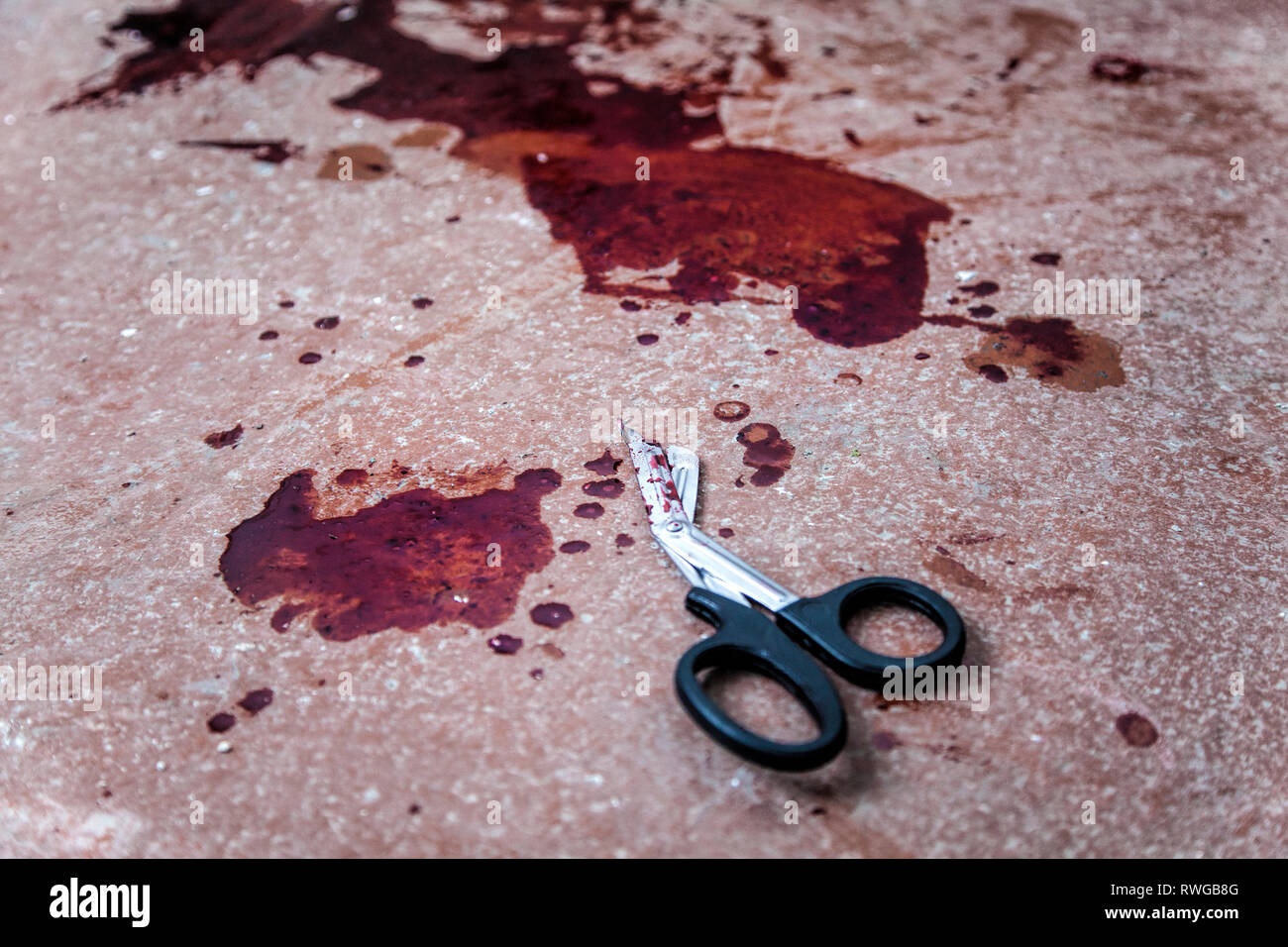 Trauma cesoie giacente sul piano con macchie di sangue umano intorno a. Foto Stock